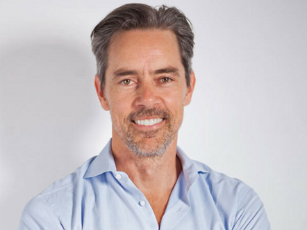 Facilitator Martin Beeche photographed against a white background. He wears a light blue shirt.